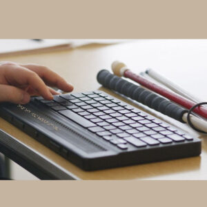 The a man's hand on Mantis Q40 integrated Qwerty and Braille Display.