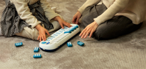 Taptilo Braille teaching device in a session with a student and teacher.